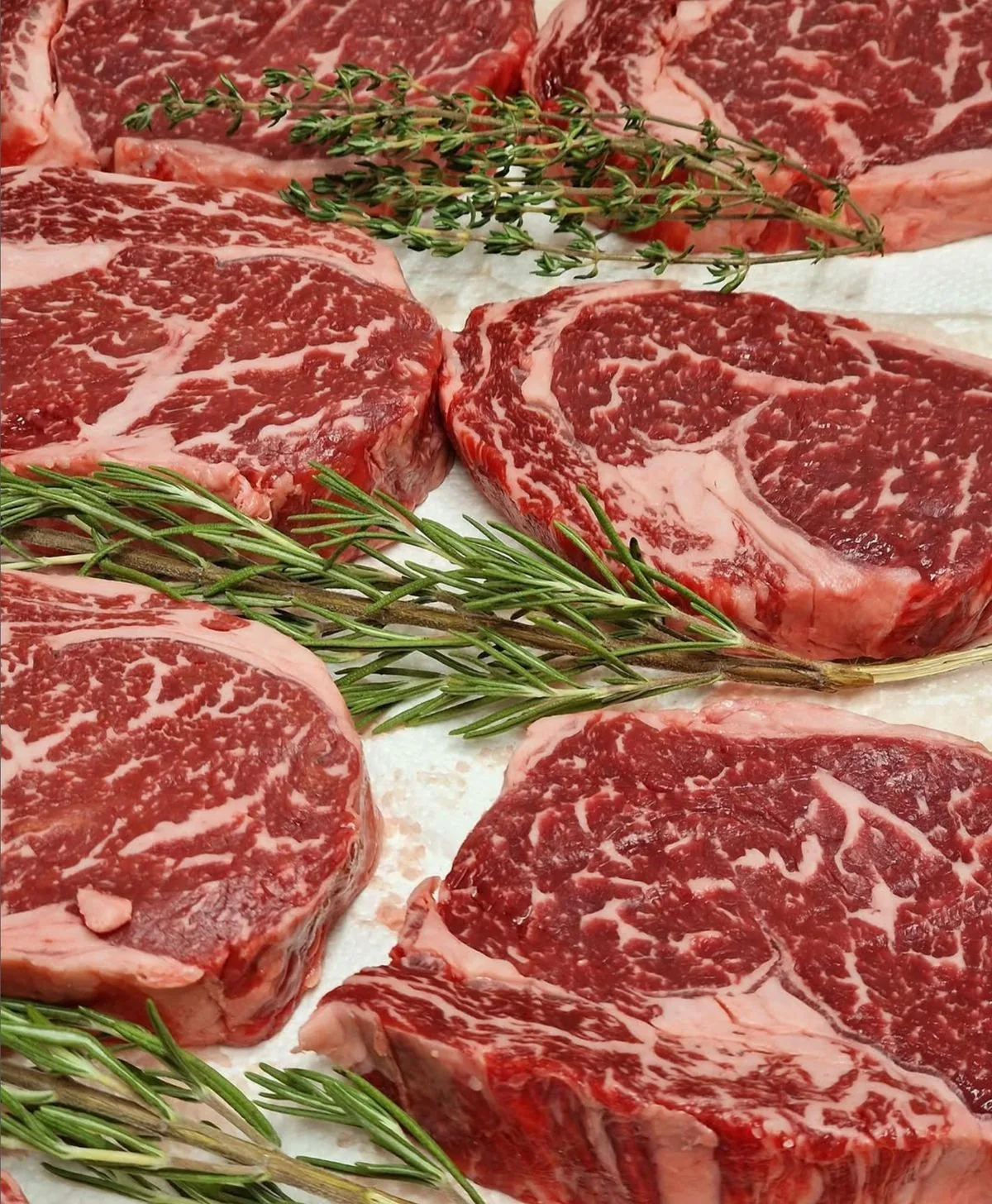 Fein marmorierte Ribeye-Steaks mit Rosmarin und Thymian